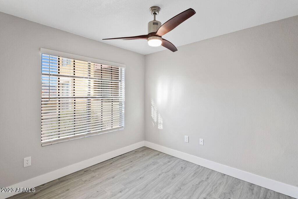 10002 North 7th Street, Unit C1 Phoenix, AZ 85020 - Photo 9 of 14 a view of an empty room with wooden floor and a window