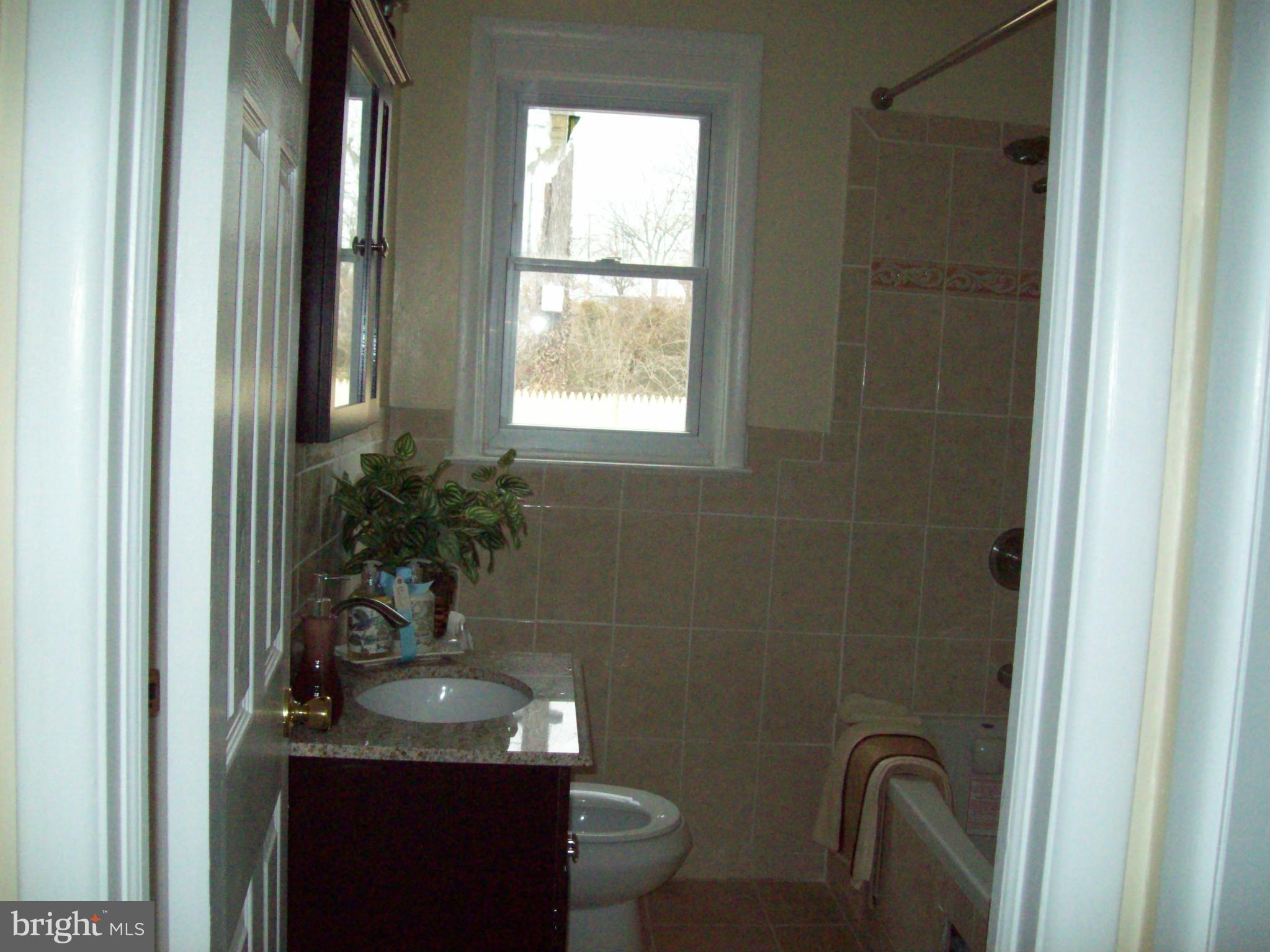 3516 Mayfair Road Baltimore, MD 21207 - Photo 4 of 10 a bathroom with a granite countertop sink a toilet and shower