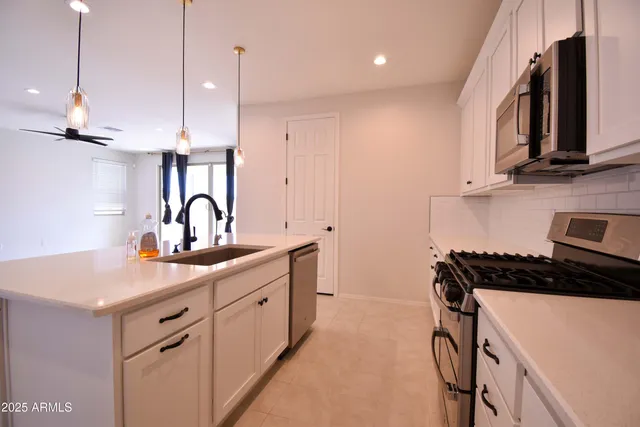 a kitchen with a sink appliances and cabinets