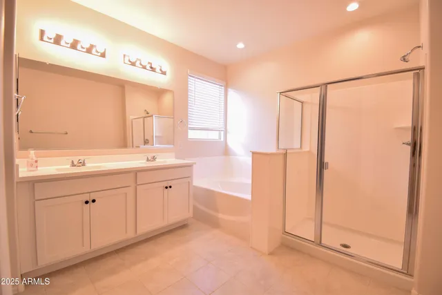 a spacious bathroom with a double vanity sink a mirror and a bathtub