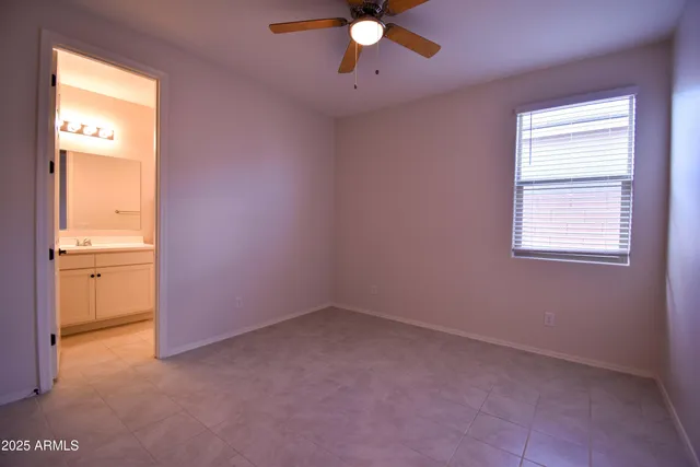 an empty room with a window and a chandelier fan