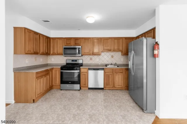 a kitchen with granite countertop white cabinets and stainless steel appliances