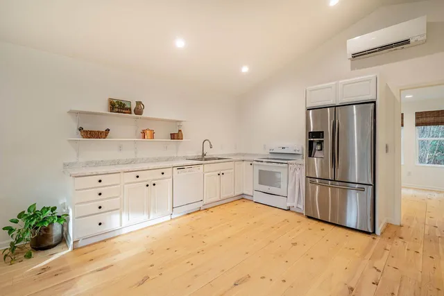 a kitchen with granite countertop white cabinets and stainless steel appliances