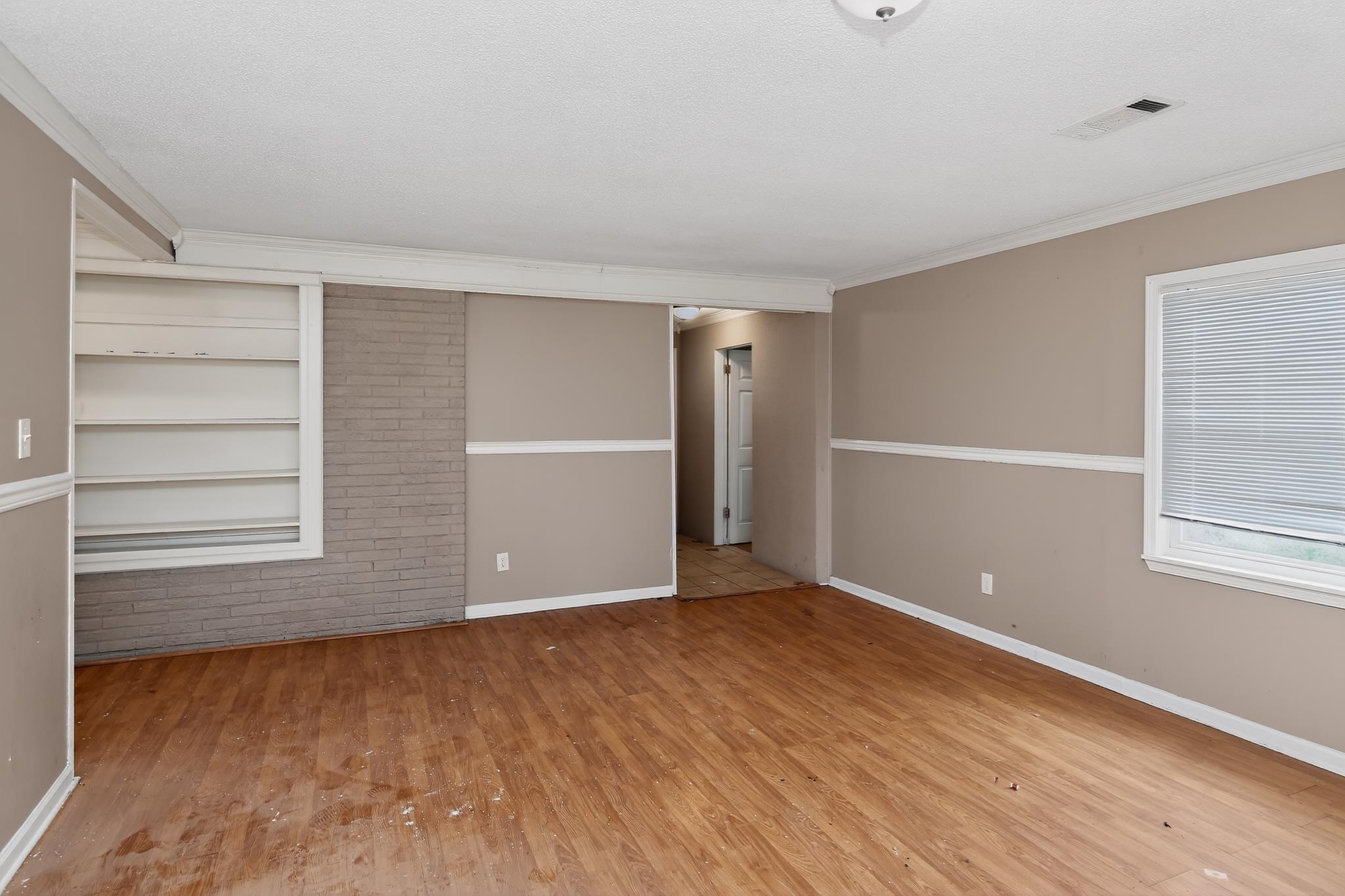1403 Old Hickory Road Memphis, TN 38116 - Photo 6 of 31 Spacious interior room featuring wood-finish flooring, neutral wall tones, and white crown molding