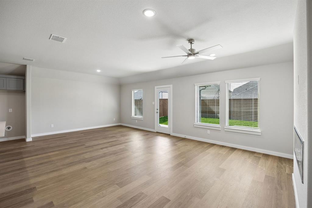 1441 Companero Street Haslet, TX 76052 - Photo 13 of 33 a view of an empty room with wooden floor and a window