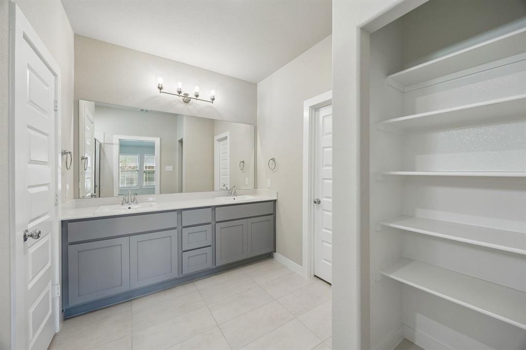 1441 Companero Street Haslet, TX 76052 - Photo 18 of 33 a spacious bathroom with a double vanity sink a mirror and a bathtub