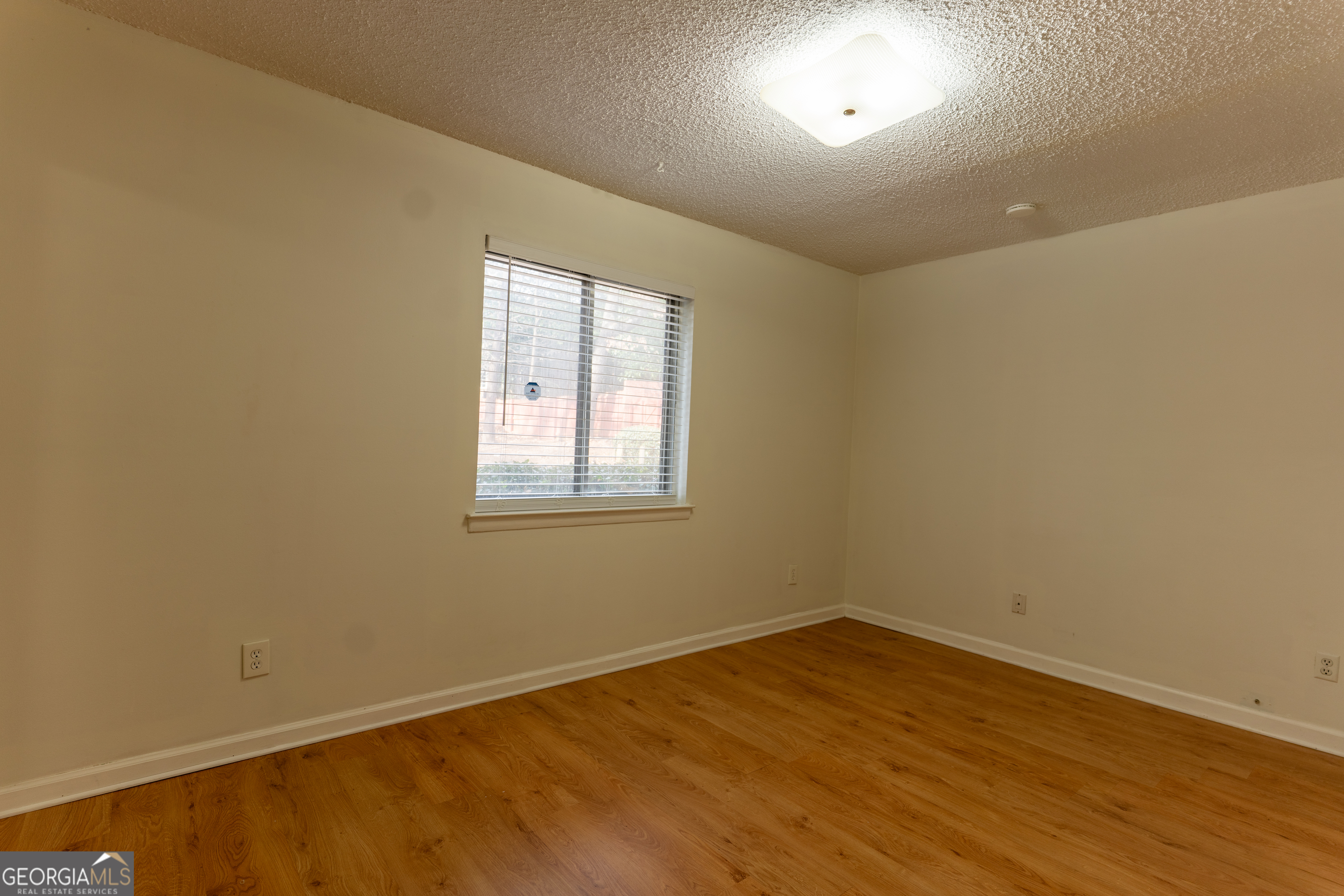 4266 Roswell Road Northeast, Unit K2 Atlanta, GA 30342 - Photo 14 of 18 an empty room with wooden floor and windows