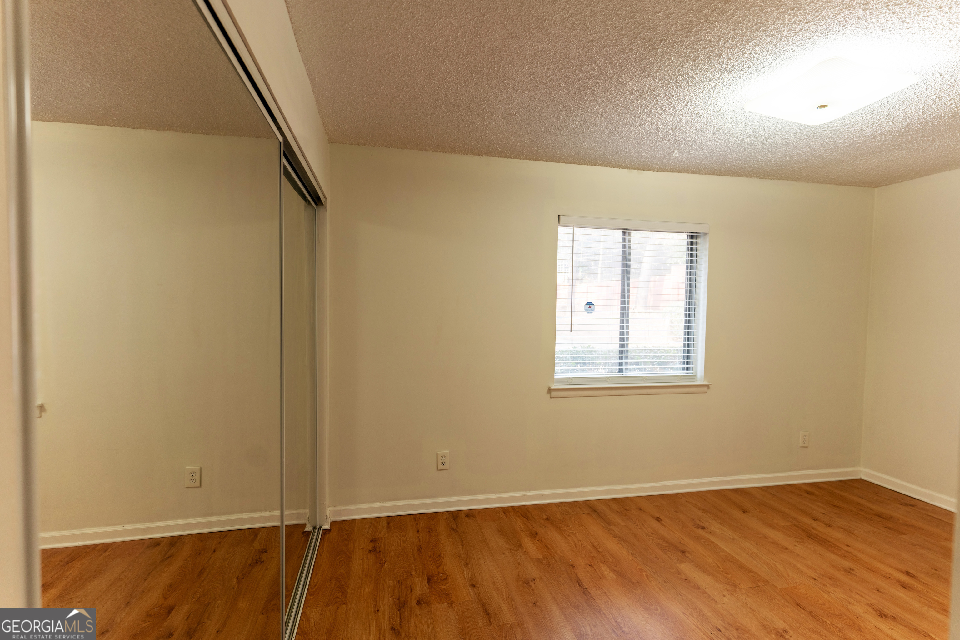 4266 Roswell Road Northeast, Unit K2 Atlanta, GA 30342 - Photo 15 of 18 an empty room with wooden floor and windows
