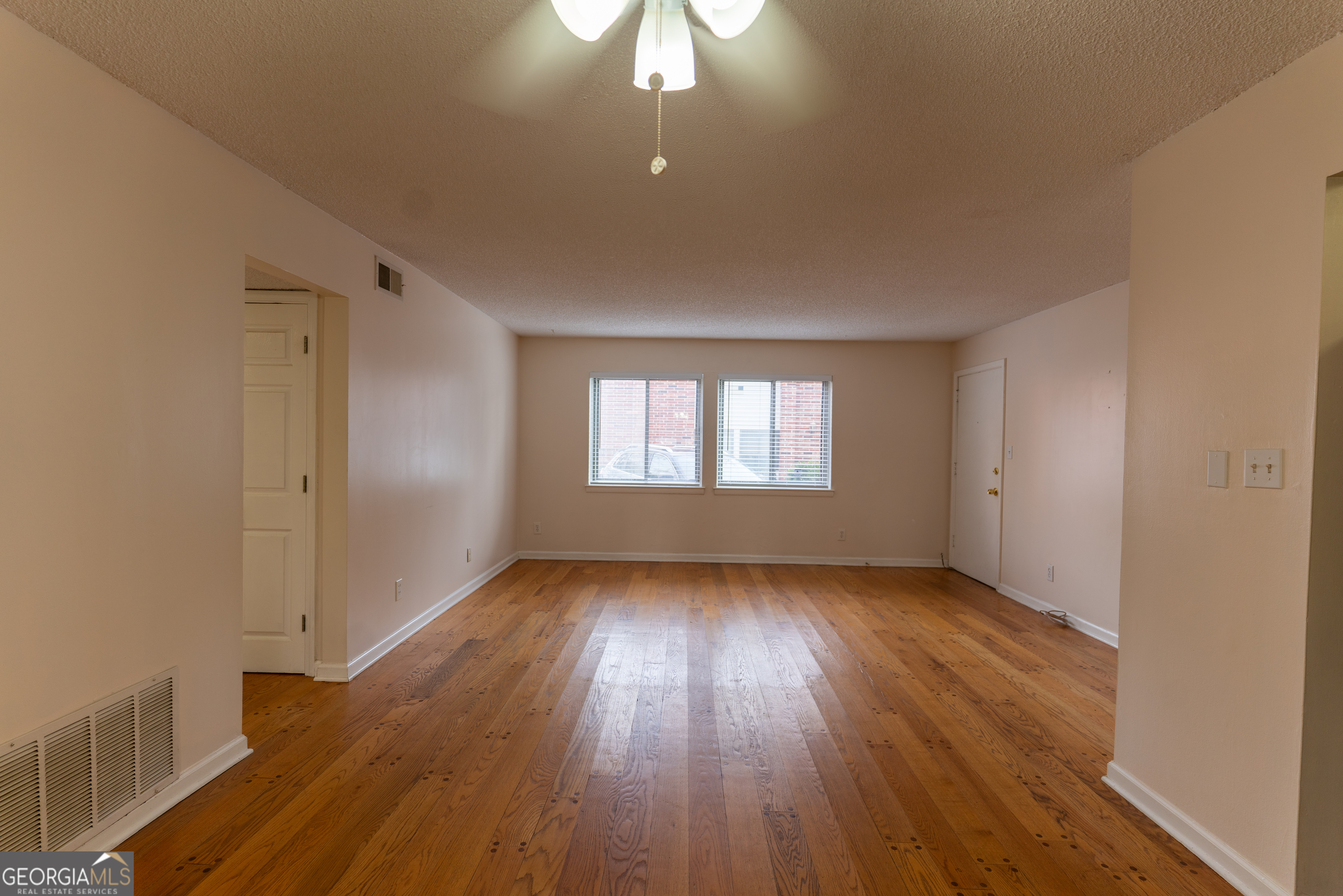 4266 Roswell Road Northeast, Unit K2 Atlanta, GA 30342 - Photo 4 of 18 an empty room with wooden floor and windows