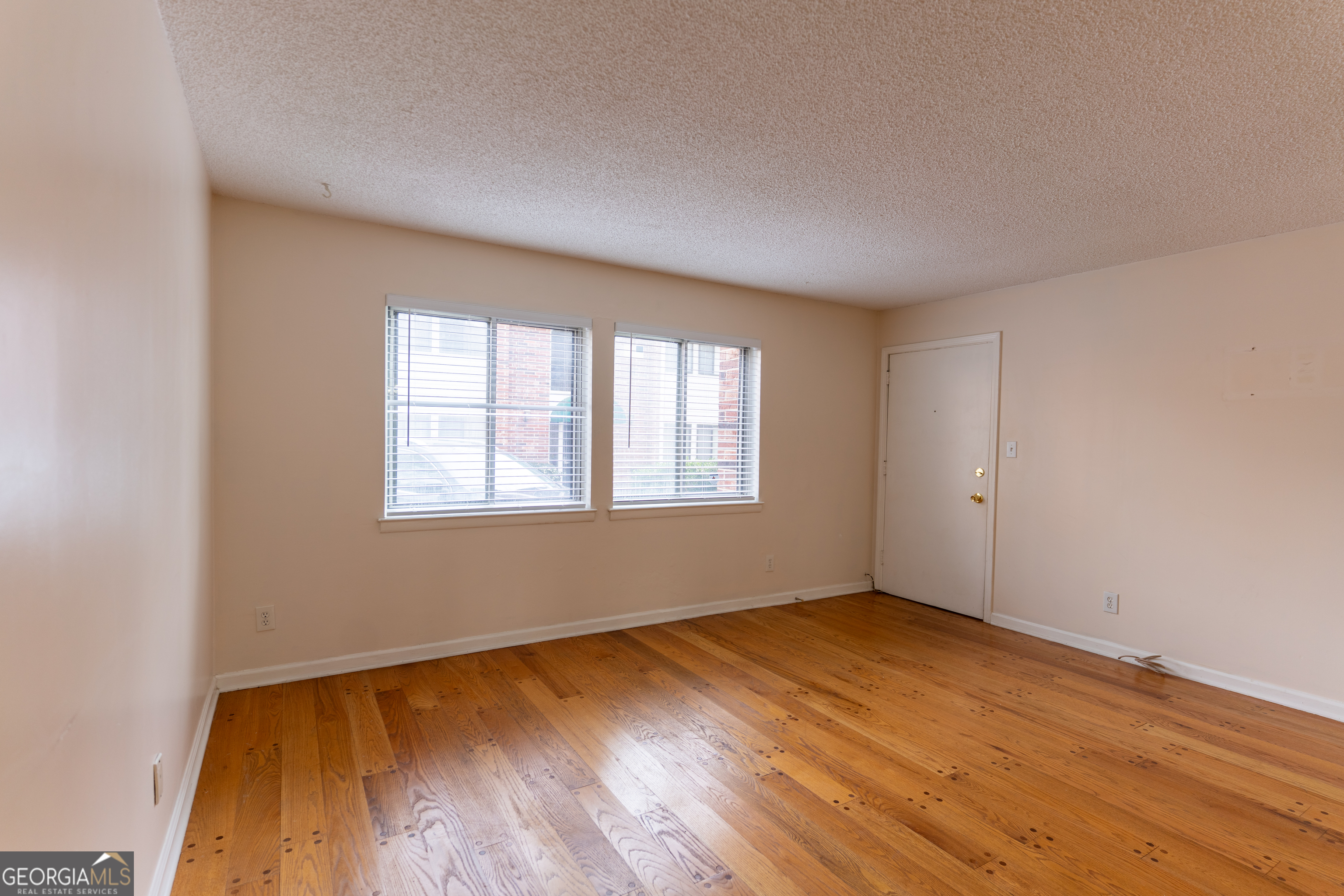 4266 Roswell Road Northeast, Unit K2 Atlanta, GA 30342 - Photo 5 of 18 an empty room with wooden floor and windows