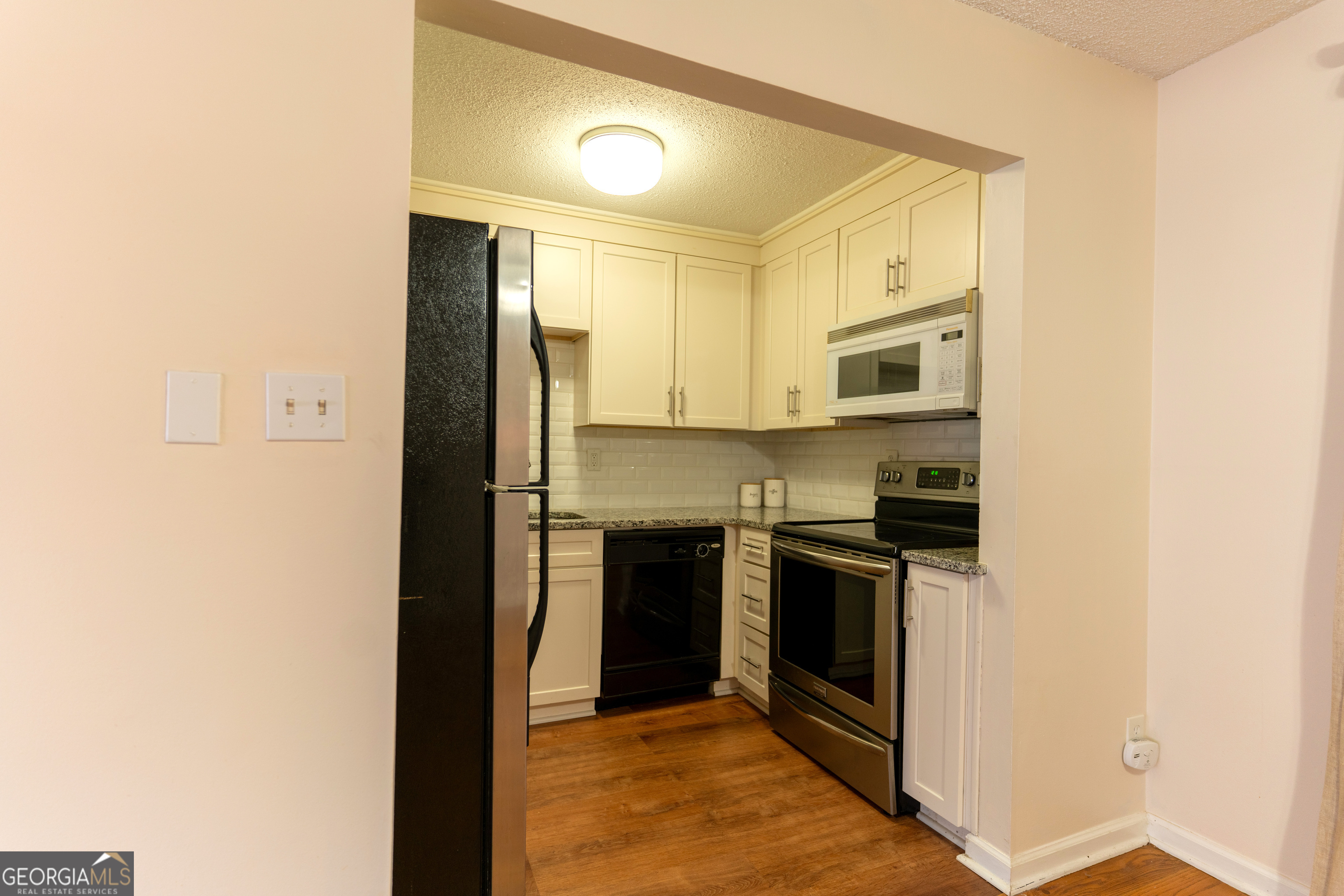 4266 Roswell Road Northeast, Unit K2 Atlanta, GA 30342 - Photo 7 of 18 a kitchen with stainless steel appliances granite countertop a stove and a refrigerator