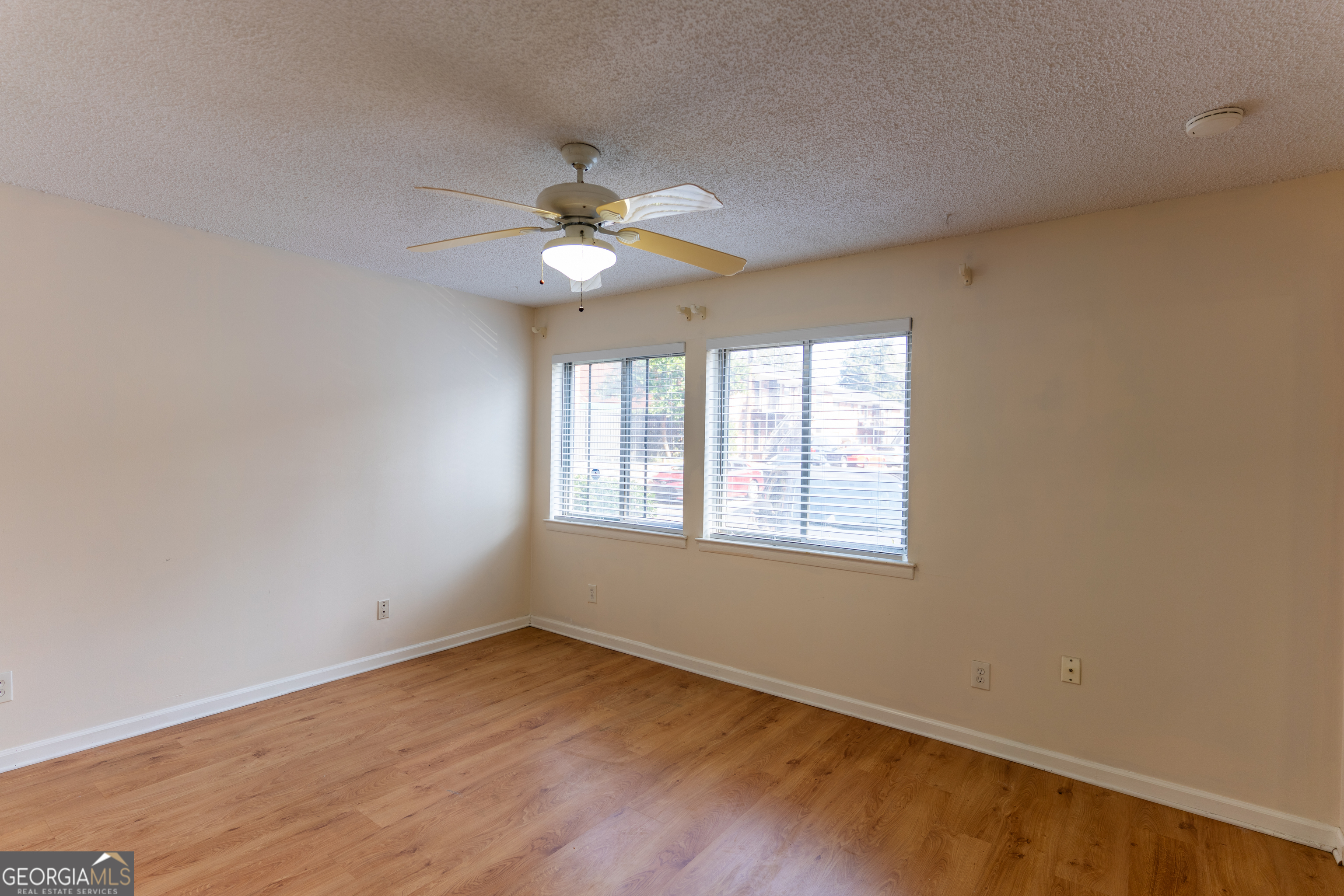 4266 Roswell Road Northeast, Unit K2 Atlanta, GA 30342 - Photo 8 of 18 an empty room with wooden floor fan and windows