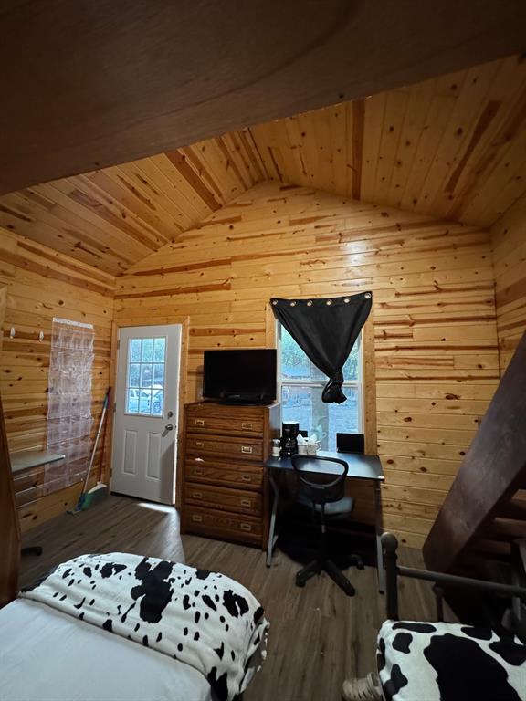 429 County Road 1191 Kopperl, TX 76652 - Photo 12 of 30 Bedroom with wood ceiling, wooden walls, vaulted ceiling, dark wood-type flooring, and an office area