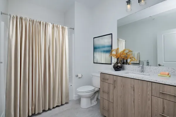 a bathroom with a granite countertop sink toilet and mirror