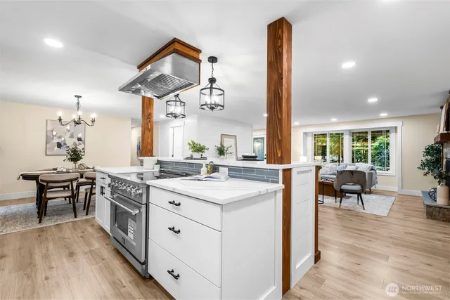a kitchen with a sink and living room with stainless steel appliances
