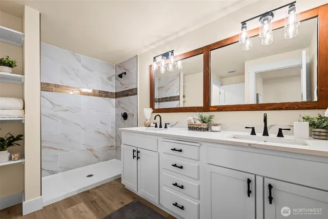 a bathroom with a double vanity sink mirror and shower
