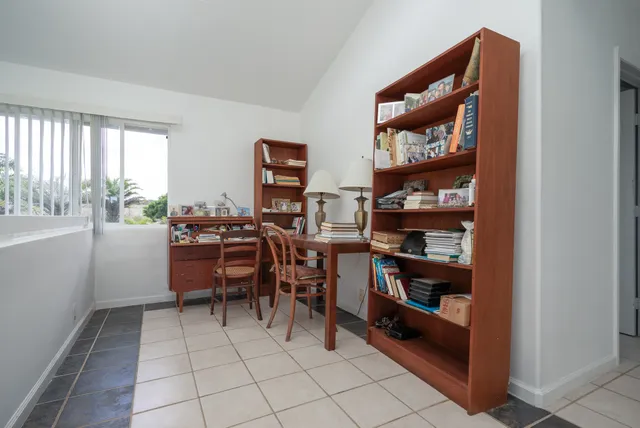 a room with furniture a bookshelf and a window