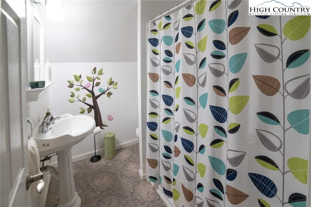 a bathroom with a sink and mirror with shower curtain