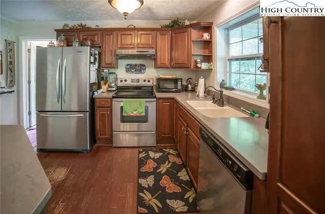 a kitchen with stainless steel appliances granite countertop a refrigerator a sink and a stove