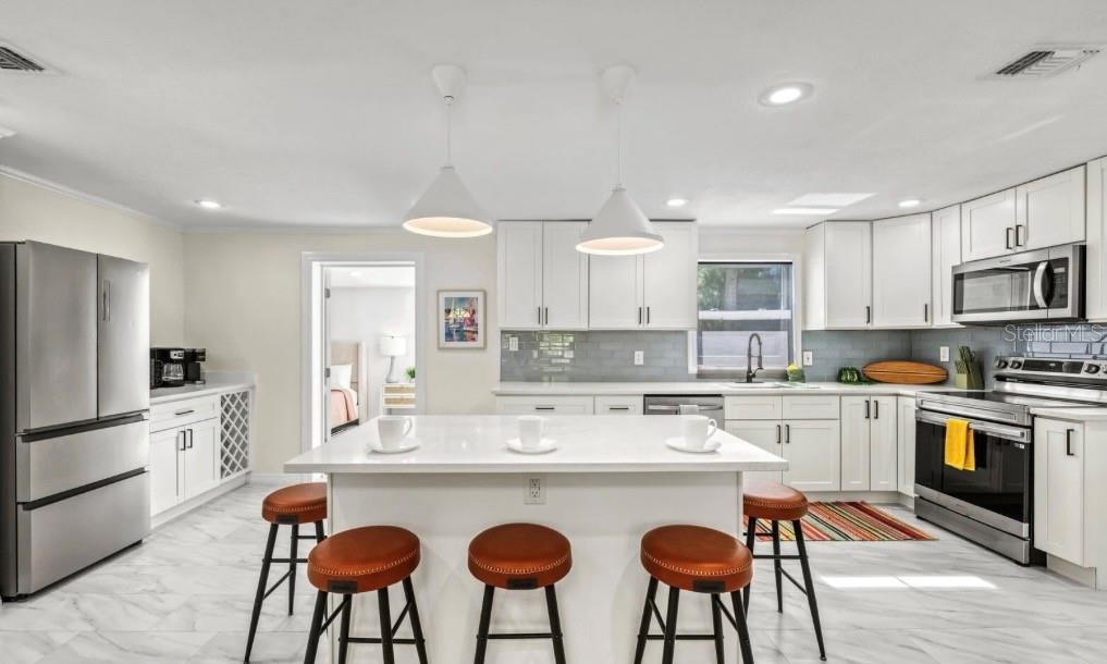 578 Companion Way Longboat Key, FL 34228 - Photo 21 of 70 a kitchen with stainless steel appliances a dining table chairs refrigerator and microwave
