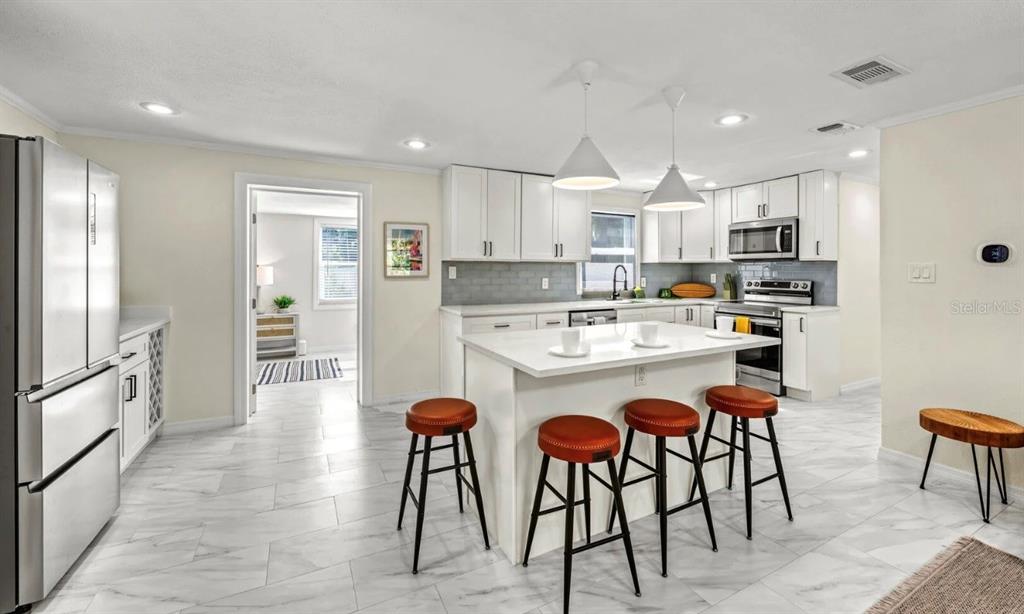 578 Companion Way Longboat Key, FL 34228 - Photo 23 of 70 a kitchen with stainless steel appliances kitchen island granite countertop a refrigerator and microwave