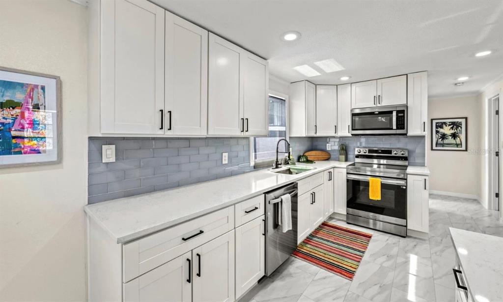 578 Companion Way Longboat Key, FL 34228 - Photo 25 of 70 a kitchen with granite countertop a stove top oven a sink a counter space and cabinets