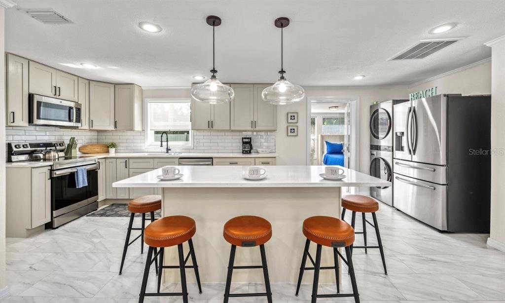 578 Companion Way Longboat Key, FL 34228 - Photo 48 of 70 a kitchen with stainless steel appliances kitchen island granite countertop a dining table chairs and a refrigerator