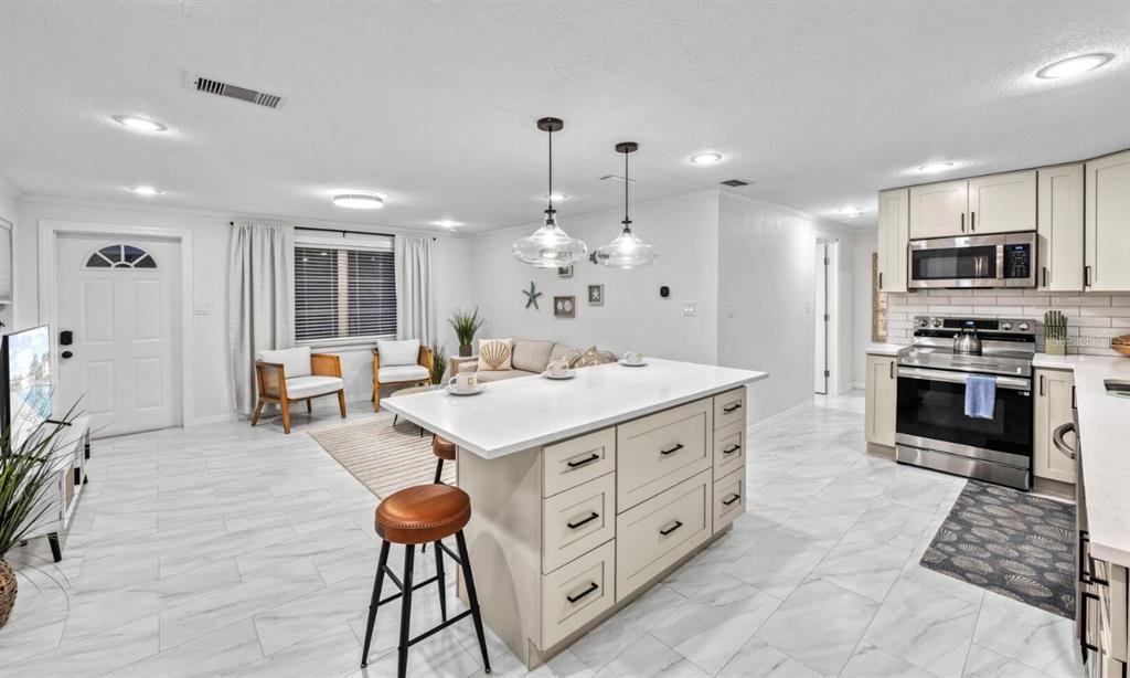 578 Companion Way Longboat Key, FL 34228 - Photo 49 of 70 a kitchen with stainless steel appliances kitchen island granite countertop a stove a sink dishwasher and a refrigerator with wooden floor