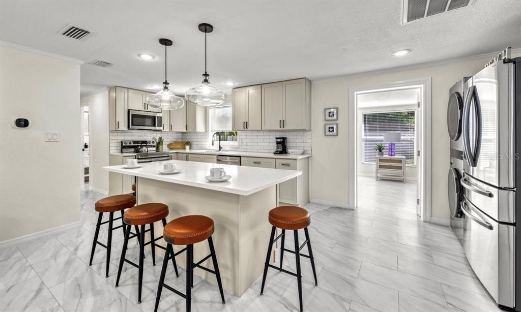578 Companion Way Longboat Key, FL 34228 - Photo 50 of 70 a kitchen with stainless steel appliances kitchen island granite countertop a dining table chairs sink and cabinets