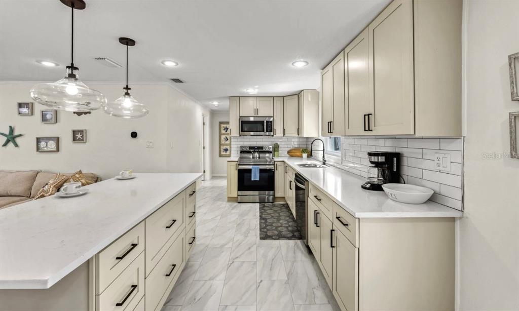 578 Companion Way Longboat Key, FL 34228 - Photo 52 of 70 a kitchen with stainless steel appliances kitchen island granite countertop a sink and dishwasher a stove top oven with wooden floor