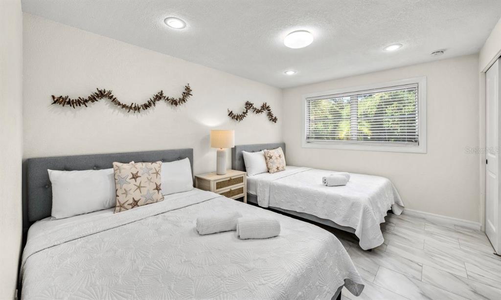 578 Companion Way Longboat Key, FL 34228 - Photo 61 of 70 a bedroom with two beds and a chandelier