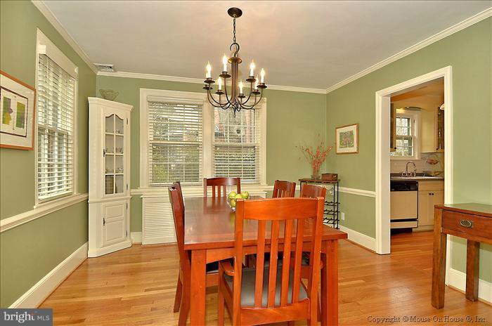 9423 Thornhill Road Silver Spring, MD 20901 - Photo 29 of 30 a dining room with wooden floor a chandelier a glass table and chairs