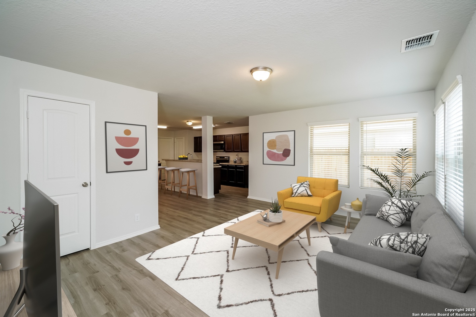 a living room with furniture and a wooden floor