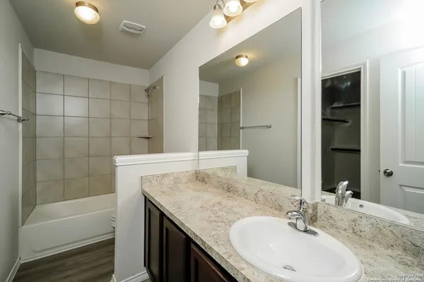 a bathroom with a granite countertop sink and a mirror
