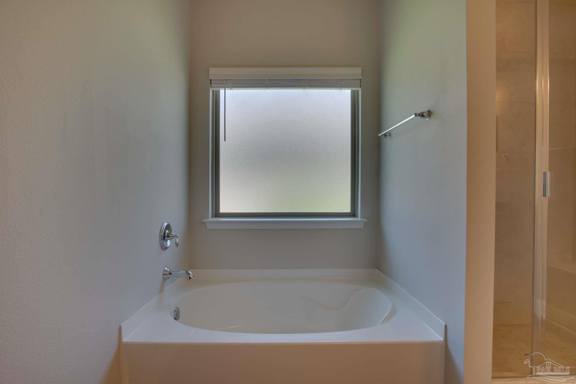 6239 Ladera Trail Pace, FL 32571 - Photo 19 of 27 a white bath tub sitting in a bathroom next to a window