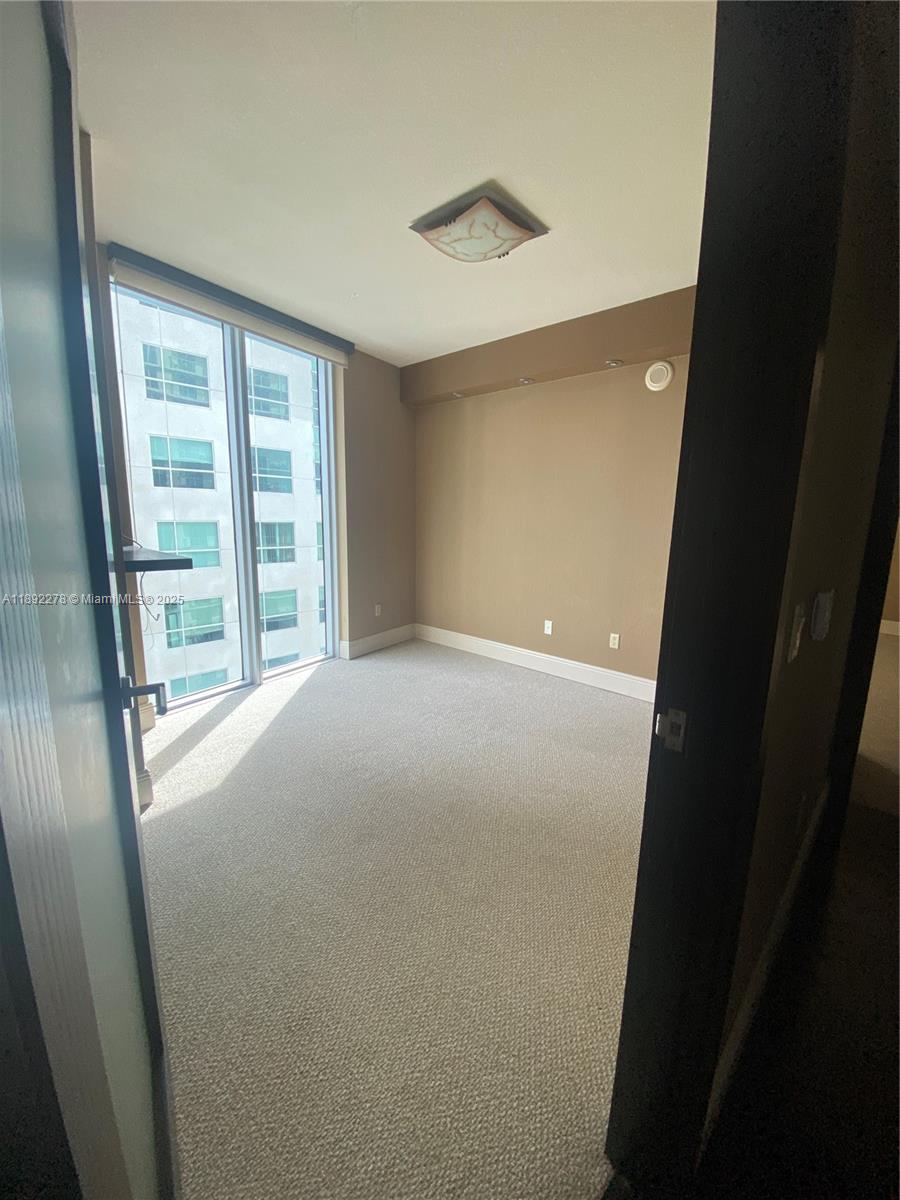 185 Southwest 7th Street, Unit 2312 Miami, FL 33130 - Photo 19 of 32 a view of empty room with wooden floor and fan