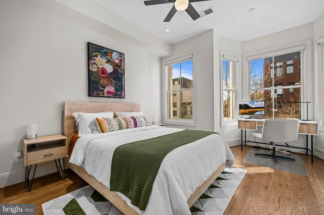 a bedroom with a bed wall painting and a window