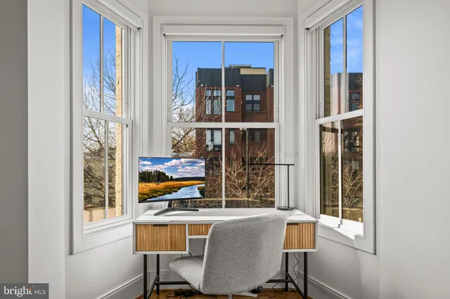 a living room with a large window and furniture