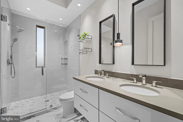 a bathroom with a double vanity sink toilet and shower