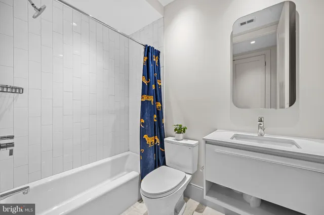 a bathroom with a sink toilet vanity tub and shower