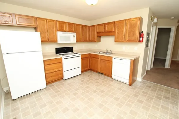 a kitchen with granite countertop a refrigerator a sink and a stove