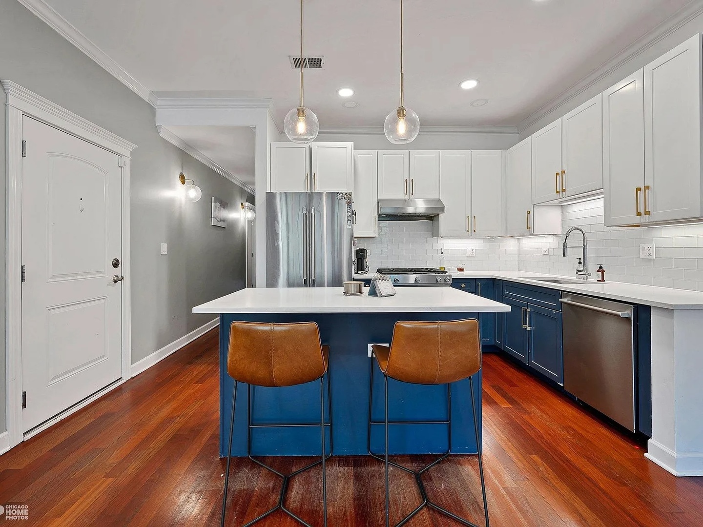 1035 West Madison Street, Unit 2 Chicago, IL 60607 - Photo 3 of 17 a kitchen with stainless steel appliances granite countertop wooden floors wooden cabinets and a refrigerator