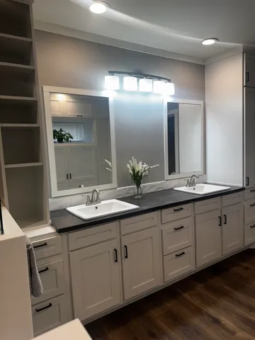 a large white bathroom with a double vanity sink and a mirror