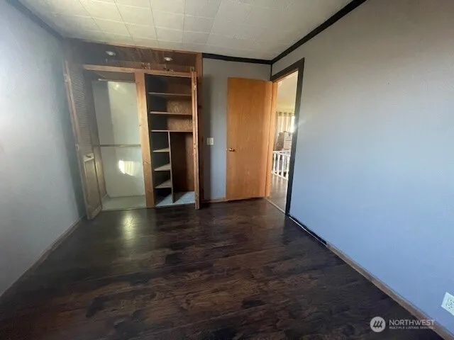 an empty room with wooden floor and closet