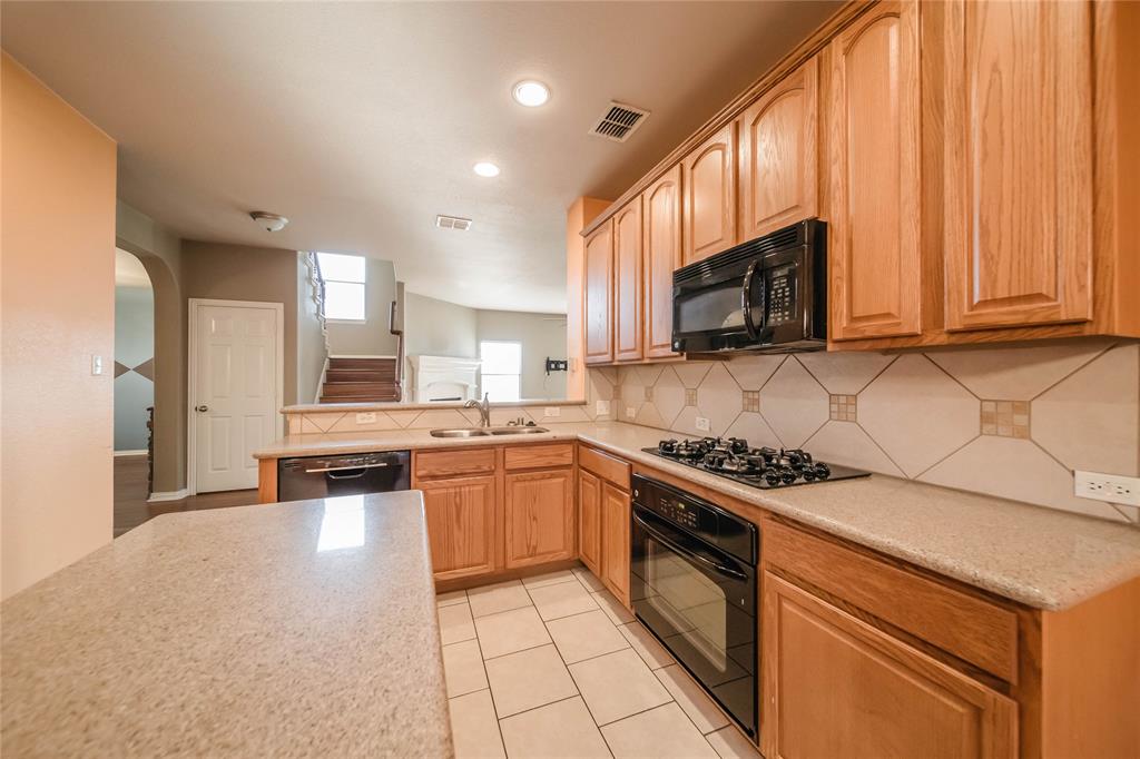 1117 Baylor Road Melissa, TX 75454 - Photo 14 of 40 a kitchen with a stove a sink and a microwave