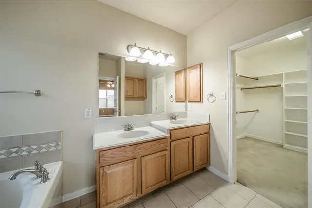 a spacious bathroom with a granite countertop sink a toilet a mirror and shower