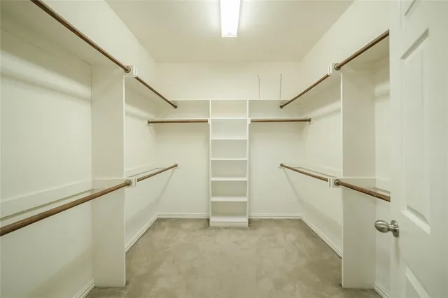 a view of walk in closet with empty racks