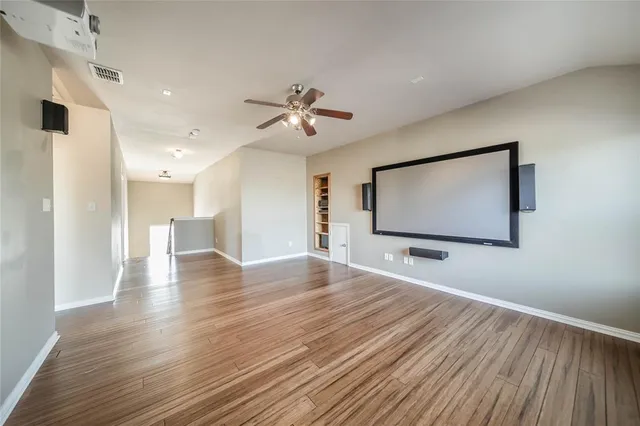 a view of a room with wooden floor and ceiling fan
