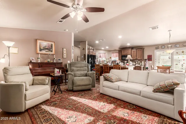a living room with furniture kitchen view and a chandelier