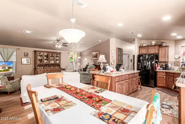 a large kitchen with kitchen island a stove a sink dishwasher a dining table and chairs with wooden floor